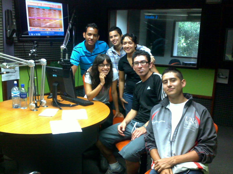 Imagen de grupo de estudiantes del equipo de producción posando en la mesa de la radio