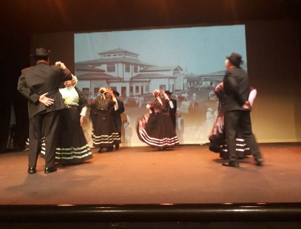 Imagen de adultos bailando con trajes típicos de negro y blanco