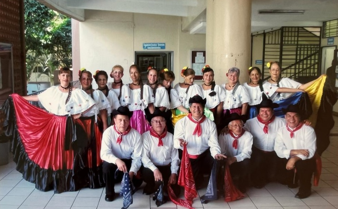 Grupo de adultos mayores con traje típico posando para fotografía en antiguo  edificio de generales.