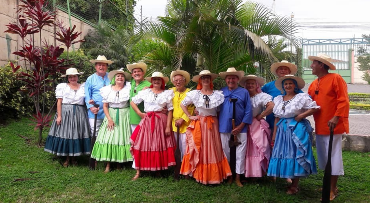 Imagen de grupo posando en zona ver con trajes multicolor típicos